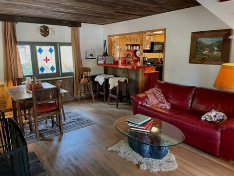 Step into the living room from the front rock deck.  The old farm table adds to the rustic charm of the retreat.