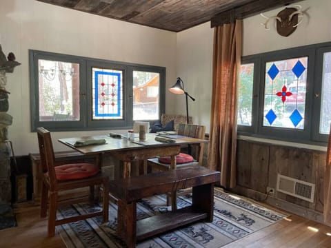 The dining room table is flanked by the wood burning fireplace and original stain glass windows!