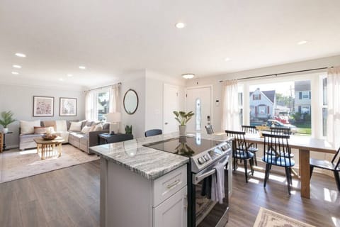 Sleek granite island with breakfast bar seating for three, perfect for casual meals or morning coffee, overlooking the dining table and living space. 🍽️☕