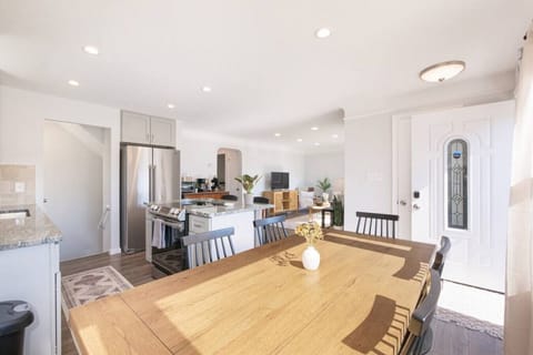 Open floorplan entry leads into a spacious living/dining area opening to a modern kitchen with central island. A hallway off the kitchen serves two bedrooms and a full bath, with stairs to the upper level tucked neatly by the entrance. 🏠📐✨