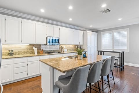 Bright and open, this full kitchen offers a stunning view and stylish bar stools, making it the perfect spot to gather and enjoy.