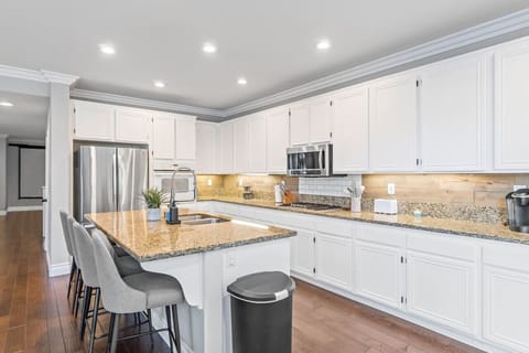 Cook with flair! This well-appointed kitchen features beautiful wood cabinetry, modern stainless steel appliances, and sophisticated stone countertops, seamlessly combining practicality with style.