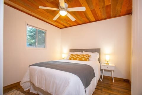 Enjoy a restful night of sleep in the two bedrooms, one of which features a queen size bed, matching nightstands with lamps, a ceiling fan, and charming wood-exposed ceilings.