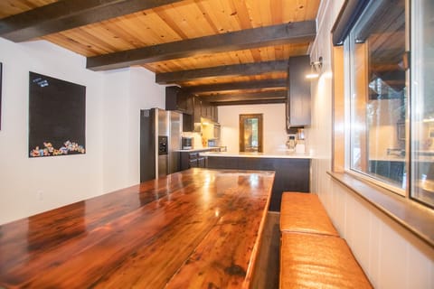 The dining area is ideally located between the living room and kitchen where you will find a large wood table with bench seating that seats 8.
