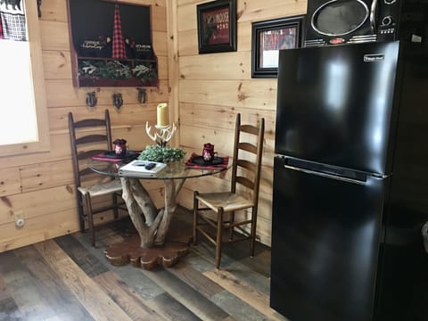 Full size refrigerator and microwave in eat in kitchen.