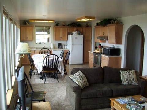 VIEW FROM THE LIVING ROOM TO THE DINING AREA AND FULL KITCHEN