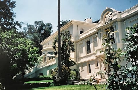 Arrive to a timeless facade framed by lush, sunlit gardens.