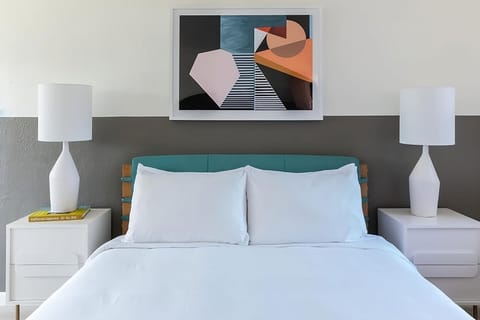 Relax into a perfectly made bed framed by modern art.