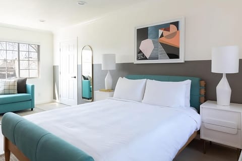 Unwind in a sunlit king room with modern coastal vibes.