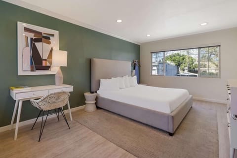 Unwind in a sunlit bedroom with stylish desk workspace.