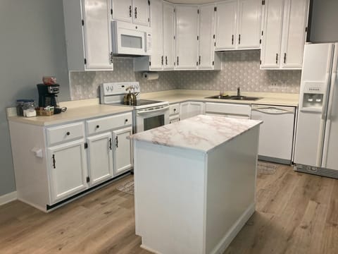 Kitchen with a fully stocked kitchen with serving set, utensils and cook ware