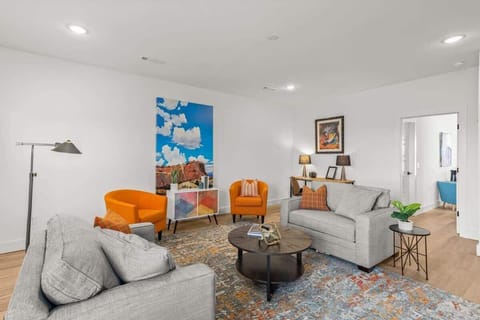 Unwind in a bright living room with curated art, comfy seating, & a modern coffee table—perfect for gatherings or quiet nights.