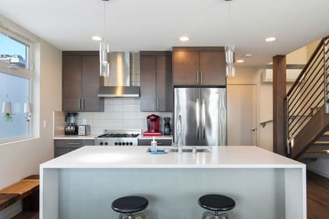 Come to the kitchen island and check if the chef needs help.