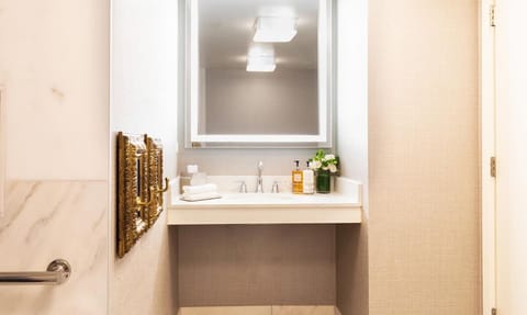 Bathroom with a shower. The essential kit and towels are provided! It features ADA mobility amenities including grab bar attached accessible seating, roll-in shower, lowered vanity in bathroom, and lowered shelf in closet.