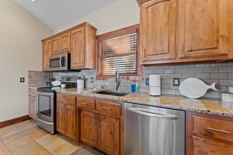 Kitchen with granite counter tops and stone backsplash
