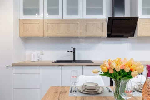 A modern kitchen with white cabinets, wooden countertops, and integrated appliances, designed for convenience and style.