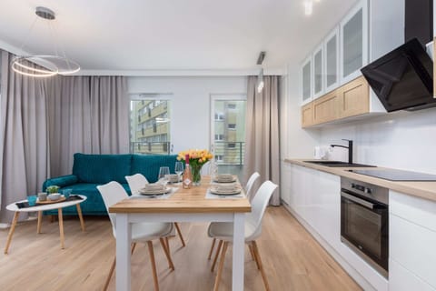 A spacious and bright open-plan kitchen and dining area, with fresh flowers on the table adding a touch of warmth.