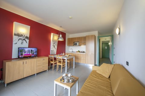 living area with sofa bed and view of kitchen and corridor