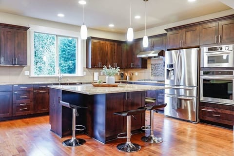With rich wood paneling, stainless steel appliances, and sleek granite countertops, this kitchen is a chef's dream