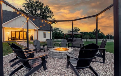 Enjoy the outdoors in this stunning fire pit area. With seating for 12, there's plenty of space to relax and enjoy the fire. At night the lights illuminate the countryside, providing a picturesque backdrop for unforgettable evenings under the stars.