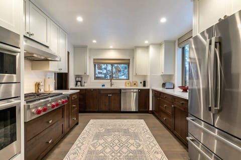 The fully equipped kitchen features top-of-the-line stainless steel appliances such as the 36” Wolf stovetop range, beautiful cabinets and countertops, and a walk-in pantry.