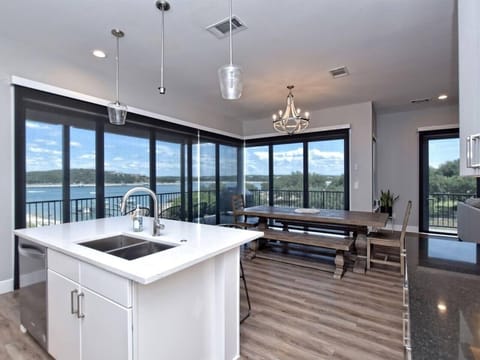 - Open dining area with lakeview windows for scenic mealtime moments - Stylish lighting enhances bright kitchen flow and vacation comfort - Spacious layout blends indoor outdoor living for easy getaway joy