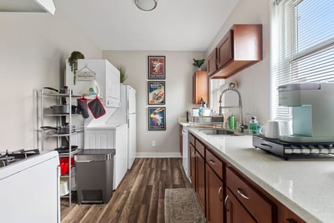 The kitchen features plenty of prep space, a gas stove, and stacked laundry.
