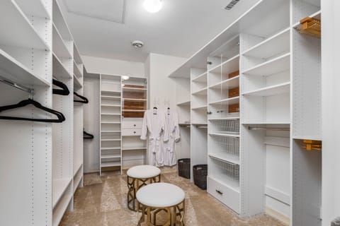Spacious primary suite closet with extensive white shelving.