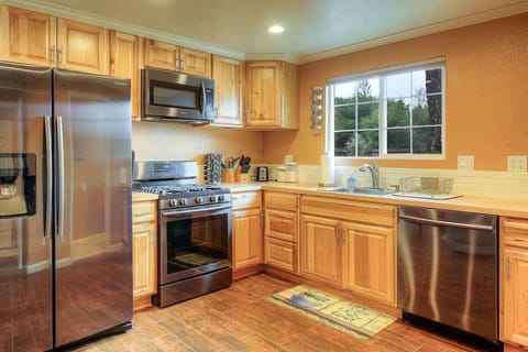 Enjoy a glass of wine and get inspired to cook a delicious meal in this kitchen with stainless steal appliances and everything you may need to prepare it with.