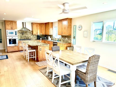 Bright dining area with stairs to the left leading up to expansive roof deck