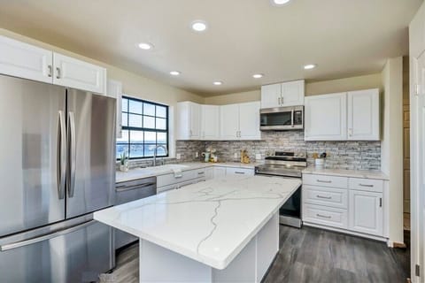 Beautiful white island kitchen with a mind blowing view of the lake