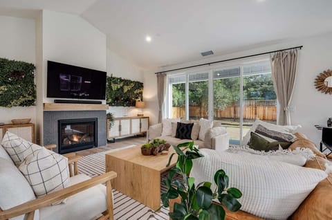 Living area with a 65 inch smart TV, SONOS surround sound system, gas fire place, board games.
