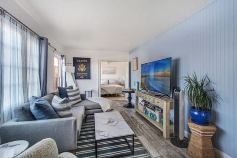 Stylish and cozy living space with a seaside vibe, smart TV, and a view of the bedroom.