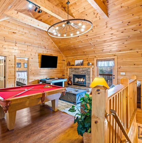Game loft with pool table, air hockey, arcade game, and big screen TV