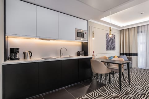 A sleek kitchen with black cabinetry, a dining corner, and integrated appliances.
