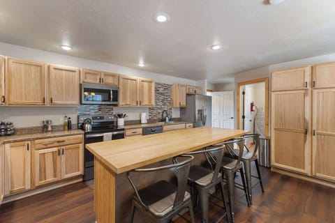The full kitchen has stainless steel appliances and an eat-in countertop.