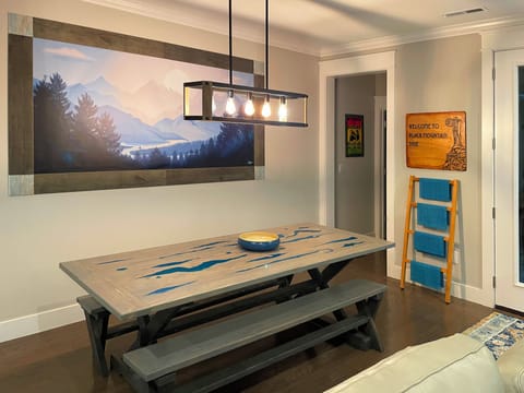 Custom Dining Room table comfortably sits 6-8 people, adorned with custom art.