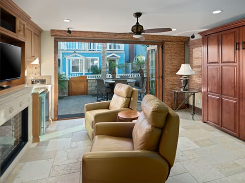 Large wooden Murphy bed blends seamlessly with the built-in cabinetry. Cozy sitting area with two plush leather recliners for relaxation.