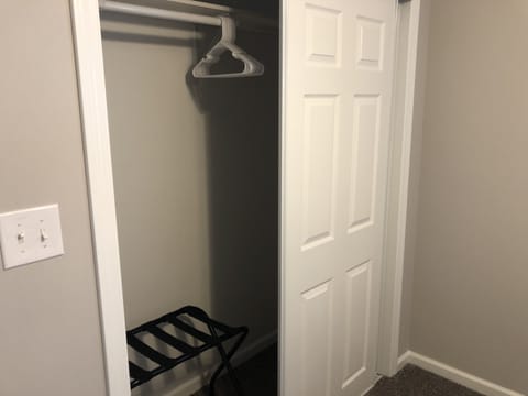 Closet in second bedroom with hangers and luggage rack