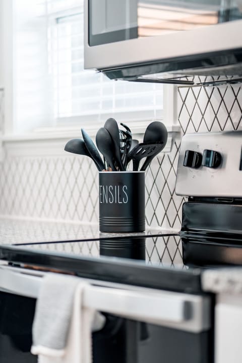 Kitchen utensils, range, oven, microwave, backsplash & stainless steel appliance