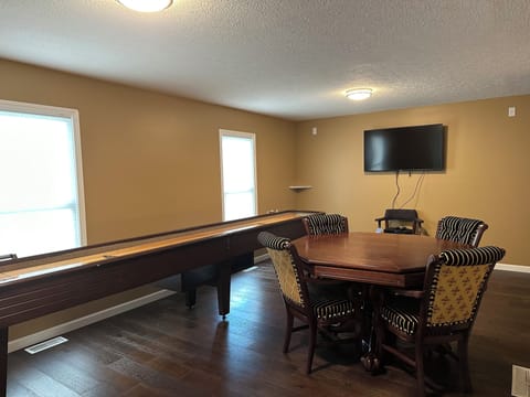 Game room with shuffleboard table and poker table
