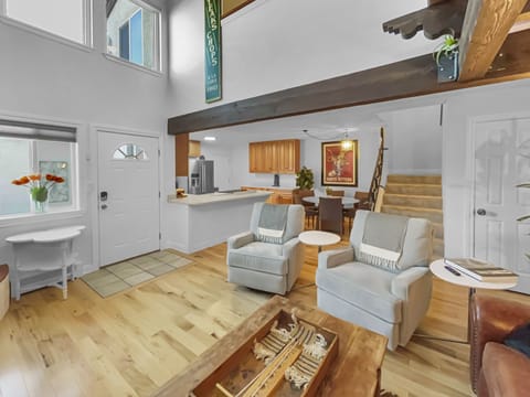 A cozy living space with two armchairs and a view into the kitchen area.