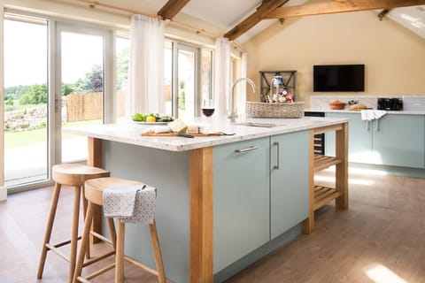 Shepherd's House - kitchen with island unit with granite work surface and doors leading out to raised patio to the front