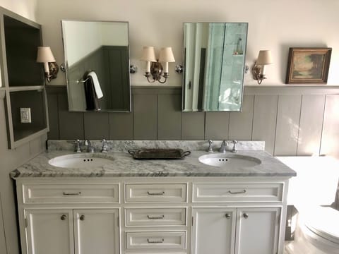 Master bathroom double vanity with marble top and radiant marble floors.