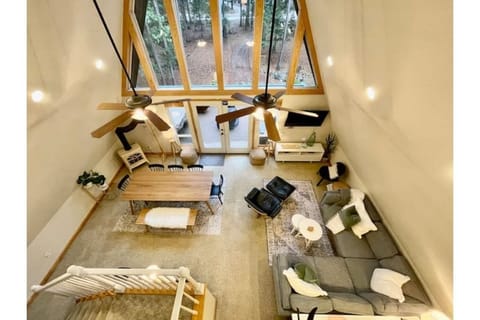 An open concept A-Frame with a beautiful view of the forest. View from the loft.