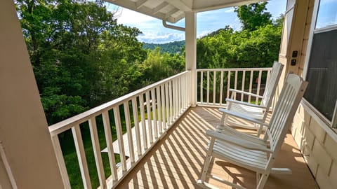 Rear balcony rocking chairs with view of backyard.