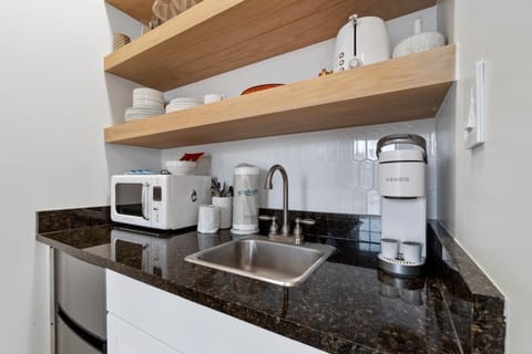 The kitchenette is equipped with granite countertops, a Keurig coffee maker, toaster, microwave, and bar refrigerator.