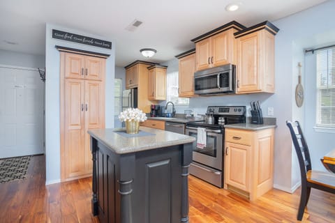 A perfect blend of natural beauty and contemporary design in this kitchen with wooden floors and a black island.