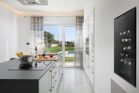 Fully equipped kitchen area of Medulin pool villa with wine cooler and stove for family vacation