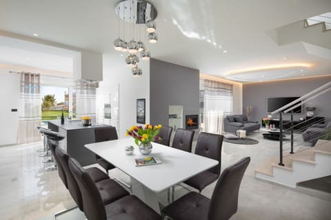 Inside of Croatia luxury holiday villa Kriya Medulin with kitchen area and dining table connected with living room for rent